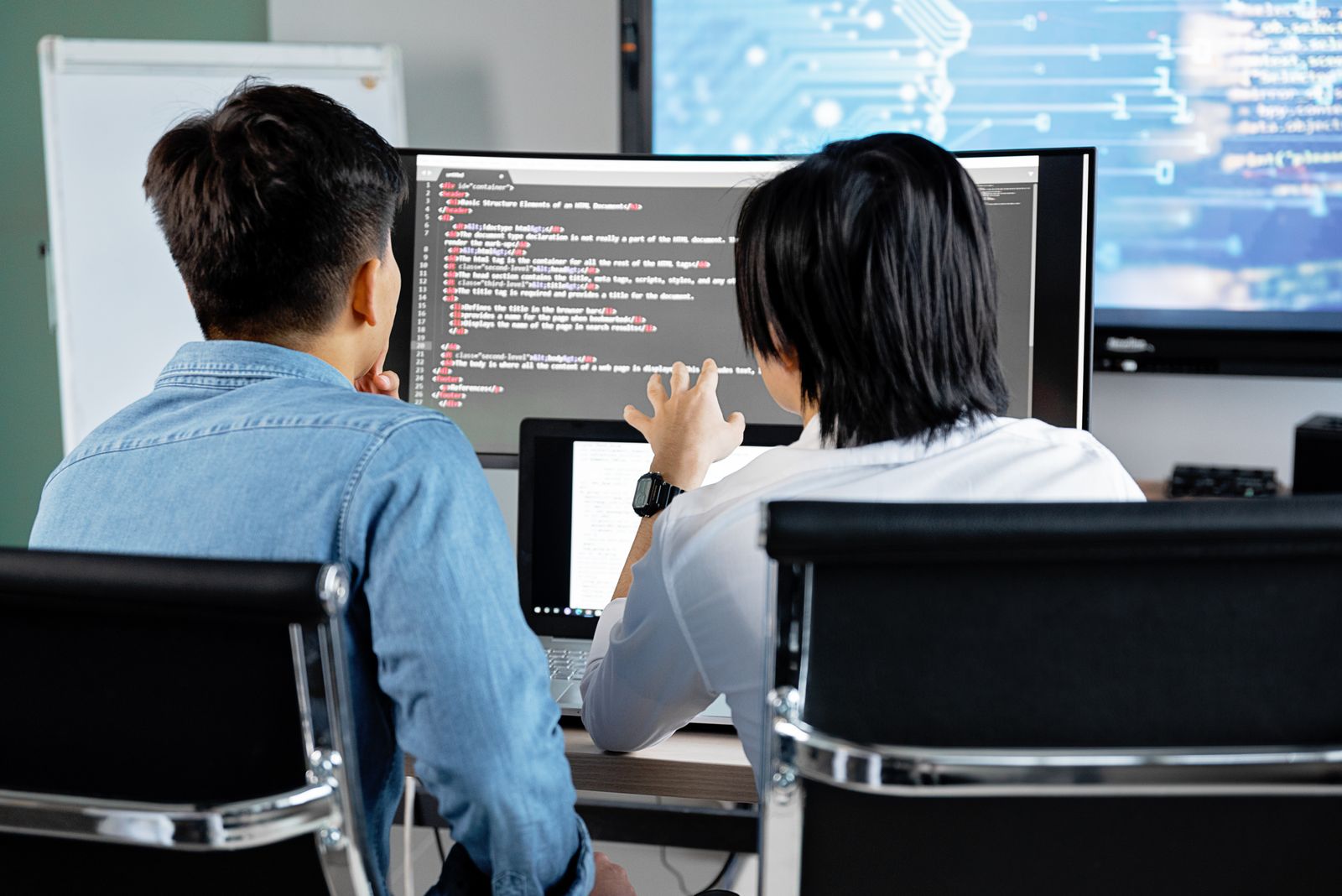 Two developers reviewing code together at a desk