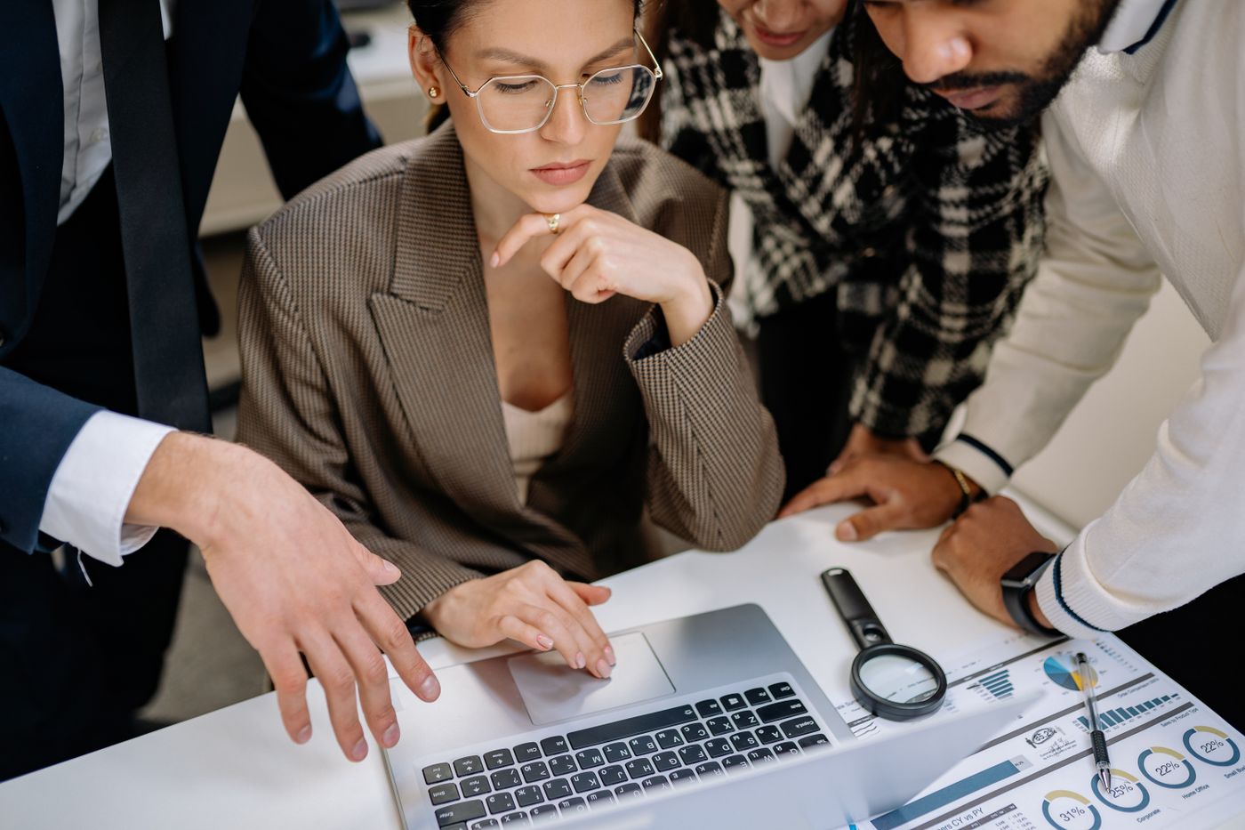 Team of professionals working together around a laptop
